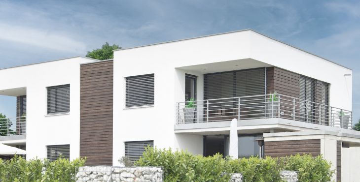 Mornes Wohnhaus im Bauhausstil mit UNILUX Holz-Alu Fenstern und Raffstore