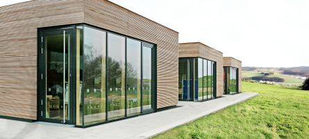 Moderne Bungalows mit großer Glasfläche und UNILUX Terrassentür Jumbo Line mit Holz-Alu Rahmen und extra großer Glasfläche