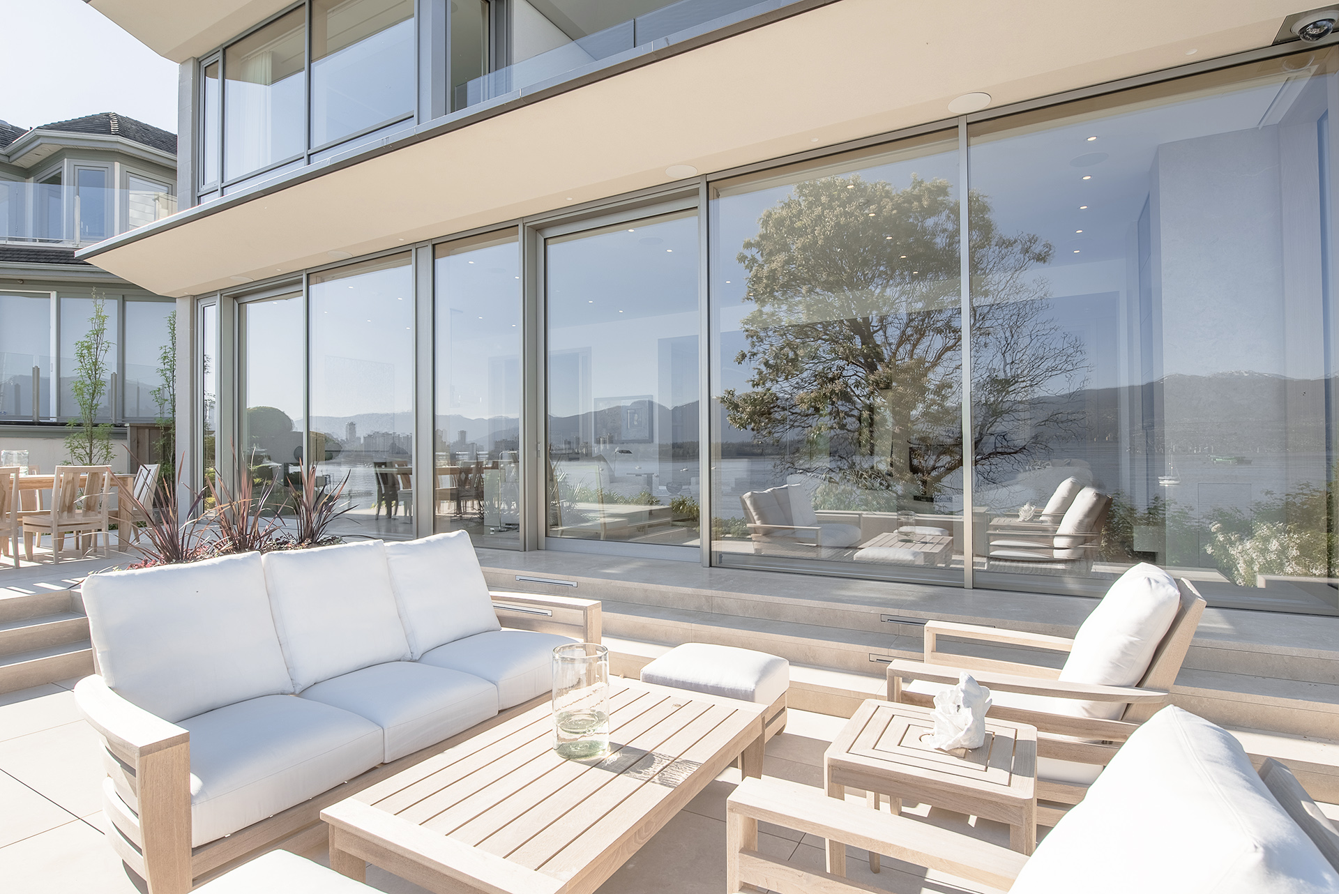 Blick von sonniger Terrasse auf großformatige UNILUX Holz-Alu Hebe-Schiebe Anlage